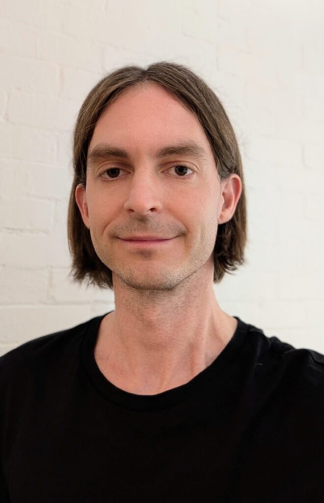 Image of Luke de Silva he is smiling and wearing a black t-shirt