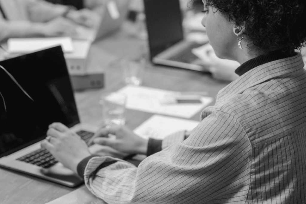 Person with short dark hair works at laptop